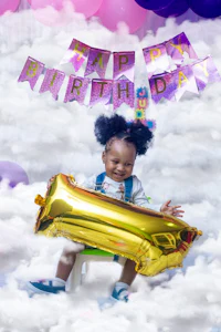 a little girl sitting on a chair holding a balloon