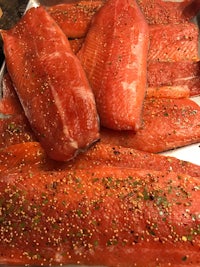 salmon fillets on a baking sheet with seasonings
