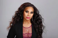 a woman in a black blazer with long black hair