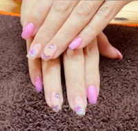 a woman with pink and purple nails on a brown carpet