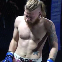 a man with a beard and tattoos in a cage