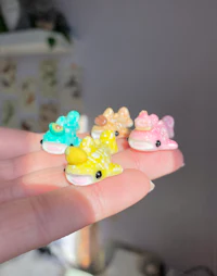 a person's hand holding a bunch of small figurines