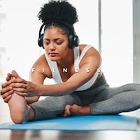 a woman wearing headphones doing yoga on a yoga mat