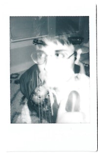 a photo of a man with glasses and a polaroid camera