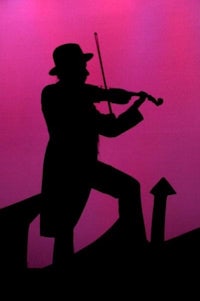 a silhouette of a man playing the violin