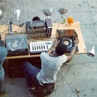 two men sitting at a table with a record player