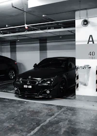 a black and white photo of a car parked in a parking garage