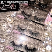four pairs of false eyelashes on a bed of pearls