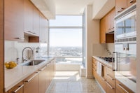 a kitchen with stainless steel appliances and a view of the city