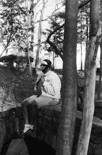 a man sitting on a bridge in the woods
