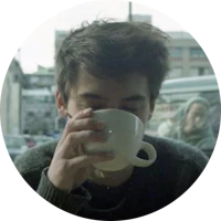 a young man drinking a cup of coffee