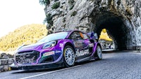 a purple rally car driving through a tunnel