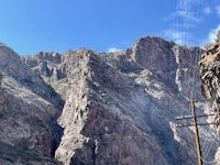 a mountain road with power lines and a canyon in the background