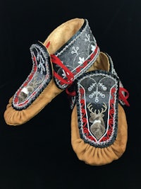 a pair of moccasins with red and black designs