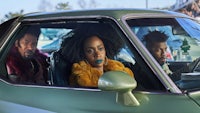 three people sitting in a green car