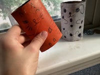 a person holding a toilet paper roll with a cat on it
