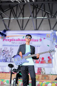 a man is playing a guitar in front of a crowd
