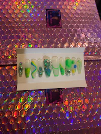 a box filled with green, blue, and purple nails