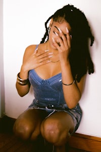 a woman with dreadlocks crouching on the floor