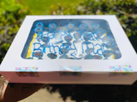 a person holding a birthday cake in a box