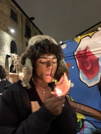 a woman smoking a cigarette in front of a graffitied van