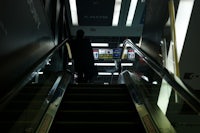 a man is walking down an escalator at an airport
