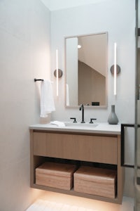 a modern bathroom with a wooden vanity and mirror