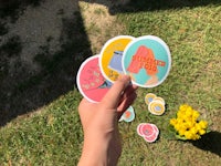 a person holding a bunch of stickers in the grass