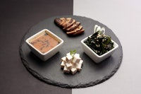 a plate with three bowls of food on it