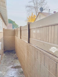 a backyard with a wooden fence and a brick wall