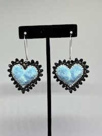 a pair of blue and black heart shaped earrings