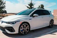 a white volkswagen golf r parked in a parking lot