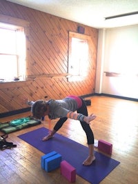 a woman practicing yoga in a room with blocks
