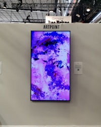 a purple painting is displayed on a wall at a trade show
