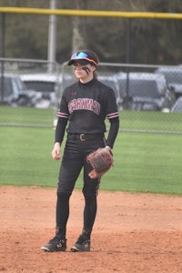 a female softball player standing on a field