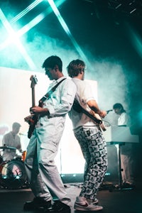 a group of people on stage with guitars and drums