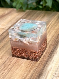 a square glass box with sand and rocks on top