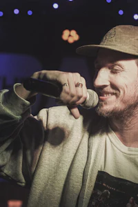 a man in a hat is holding a microphone