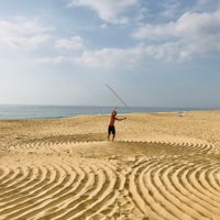 a man on a beach with a kite in the sand