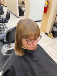 a woman is getting her hair cut in a salon