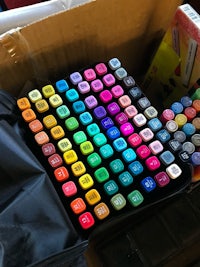 a box full of colored markers sitting on a table