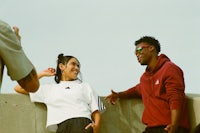 a man and a woman standing next to each other on a concrete wall