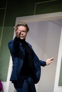 a man in a suit is dancing on a stage