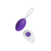 a purple sex toy next to a white button