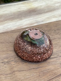 a small bowl with a spiral on it sitting on top of a wooden table