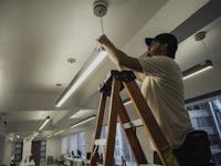 a man working on a ladder in an office