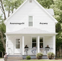 a white house with people sitting on the porch
