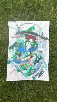 a piece of paper with green and blue paint on it