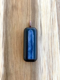 a blue glass pendant on a wooden table