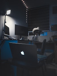 an apple laptop on a desk in a room